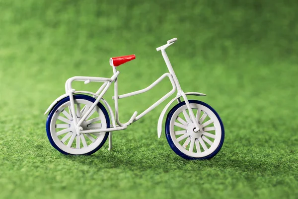 Pequeña bicicleta de juguete sobre fondo verde — Foto de Stock