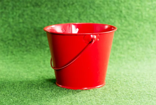 Secchio rosso su sfondo verde — Foto Stock