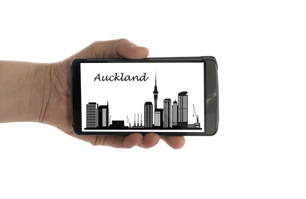 Main féminine avec téléphone portable Auckland skyline — Photo
