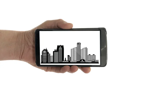 Ręka z telefonu komórkowego Detroit panoramę — Zdjęcie stockowe