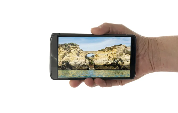 Vrouwelijke hand met mobiele telefoon algarve kliffen — Stockfoto