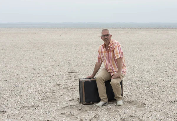 Homme assis sur une valise — Photo