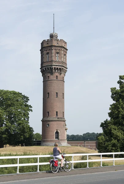 Mujer de pie frente a la torre de agua —  Fotos de Stock