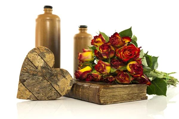 Botella de piedra con libro viejo y rosas rojas —  Fotos de Stock
