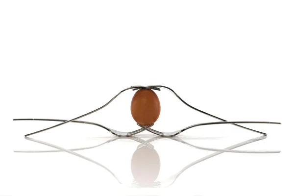 One egg and four forks in perfect balance — Stock Photo, Image