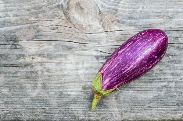 Purple eggplant on the old wooden board — Stock Photo, Image