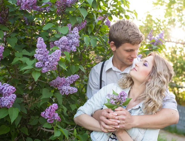 Pareja joven cerca de lilac tree — Foto de Stock