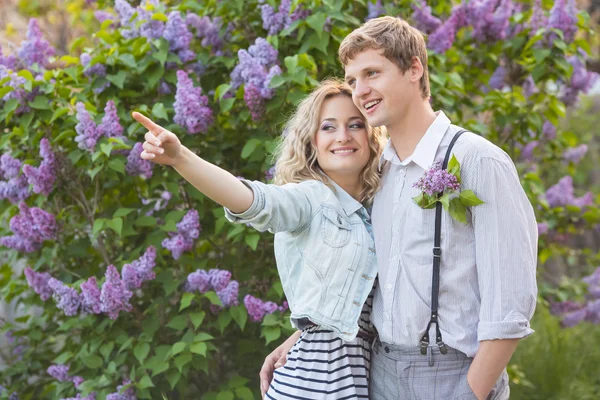 Jovem casal perto de árvore lilás — Fotografia de Stock