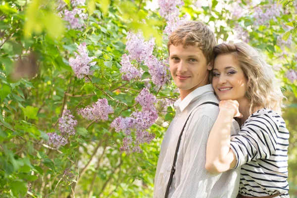 Pareja joven cerca de lilac tree — Foto de Stock