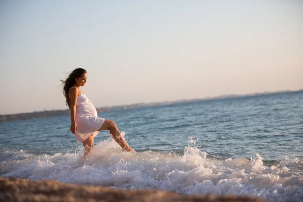 Mulher grávida andando perto do mar — Fotografia de Stock