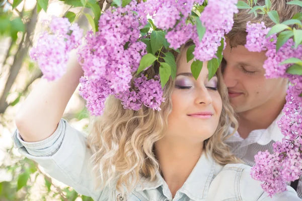 Young couple near lilac tree — Stock Photo, Image