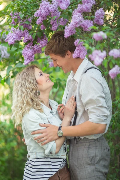 Jovem casal perto de árvore lilás — Fotografia de Stock