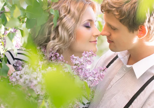 Young couple near lilac tree — Stock Photo, Image