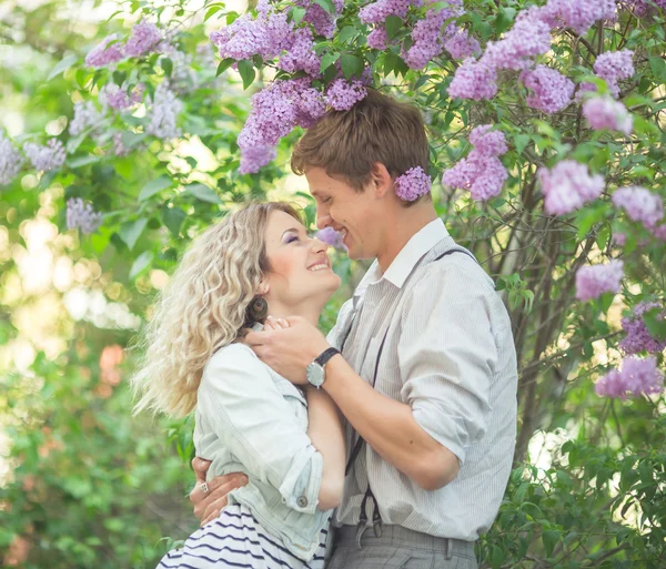 Pareja joven cerca de lilac tree — Foto de Stock