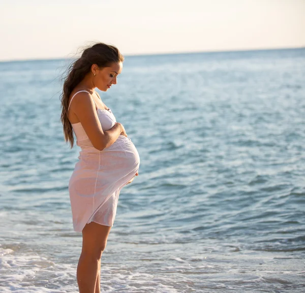 Zwangere vrouw lopen in de buurt van de zee — Stockfoto