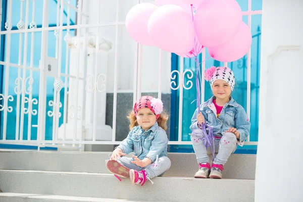 Gelukkige kleine meisjes met roze ballonnen . — Stockfoto