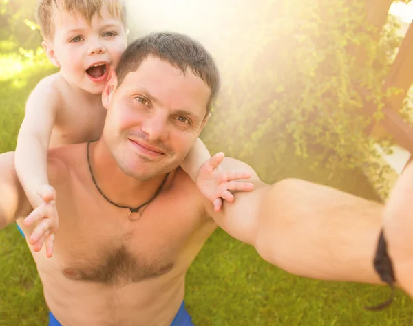 Père avec fils faisant selfie sur l'herbe — Photo