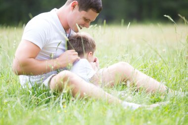Baba parkta oğluyla oynuyor.