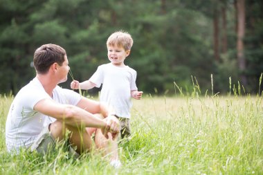 Baba parkta oğluyla oynuyor.