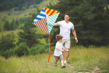 Baba parkta oğluyla oynuyor.
