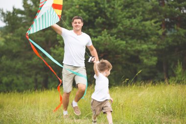 Baba parkta oğluyla oynuyor.