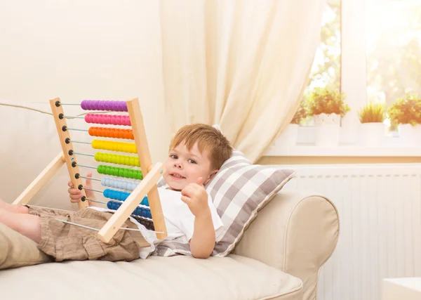 Niño jugando con abacus juguete en el interior — Foto de Stock