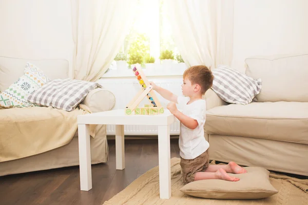 Kleine jongen spelen met speelgoed van de abacus binnenshuis — Stockfoto