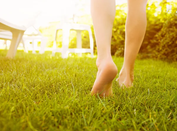 Fechar as pernas femininas andando na grama . — Fotografia de Stock