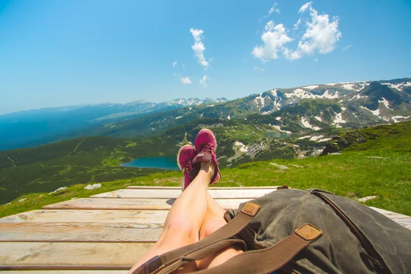 Jambes de voyageuse assise sur une haute montagne — Photo