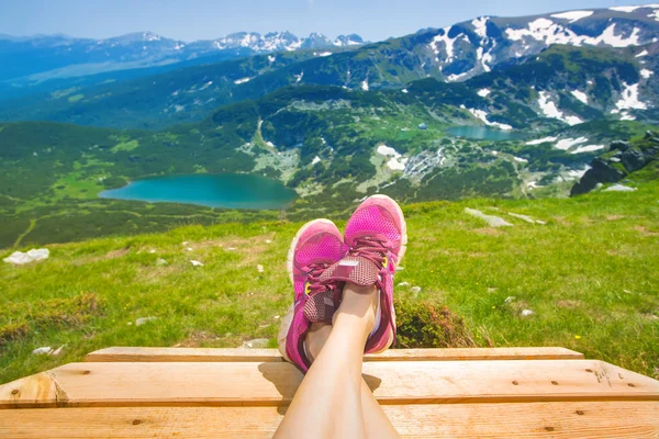 Benen van reiziger vrouw zitten op een hoge berg — Stockfoto