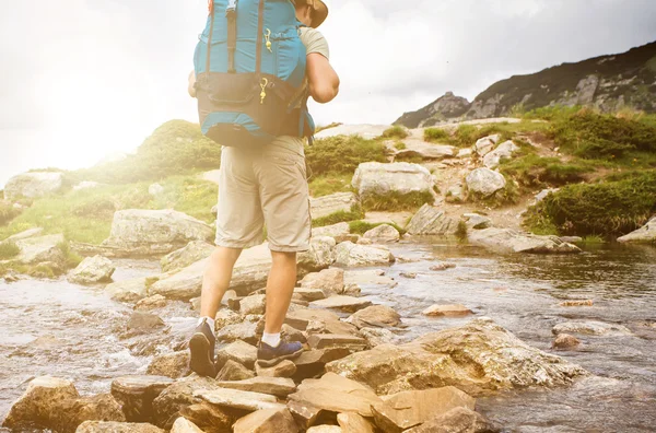 Hiker man with backpack crossing a river. — Stock Photo, Image
