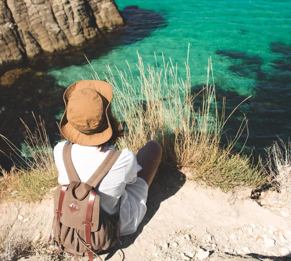 海の崖の上に立っている旅行者の女性. — ストック写真