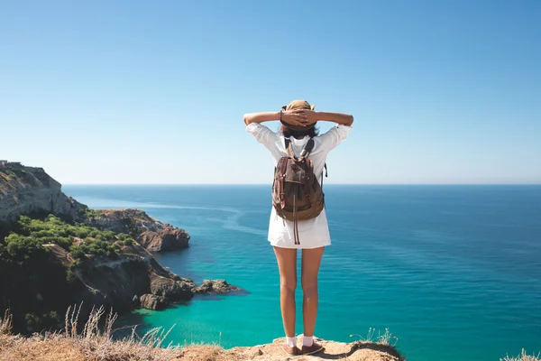 Traveler woman standing on sea cliff. — Stock Photo, Image