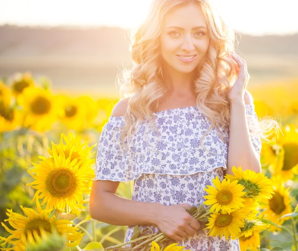 Portret van het mooie meisje met een zonnebloemen — Stockfoto