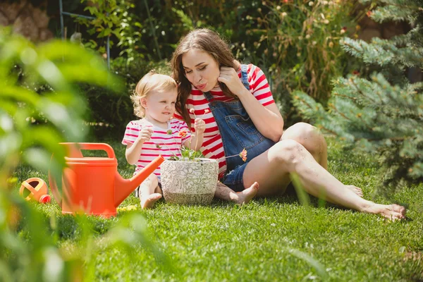 Schwangere mit kleiner Tochter im Garten. — Stockfoto