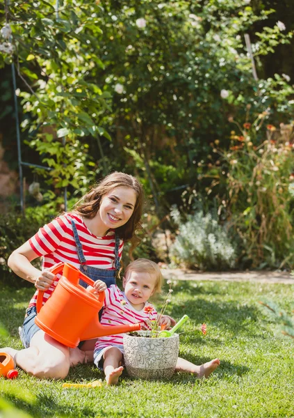 Schwangere mit kleiner Tochter im Garten. — Stockfoto
