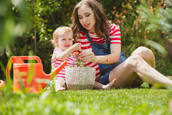 Femme enceinte avec petite fille dans le jardin . — Photo