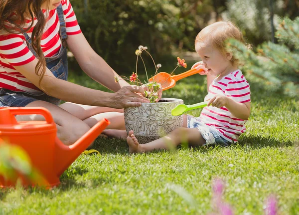 Femme enceinte avec petite fille dans le jardin . — Photo