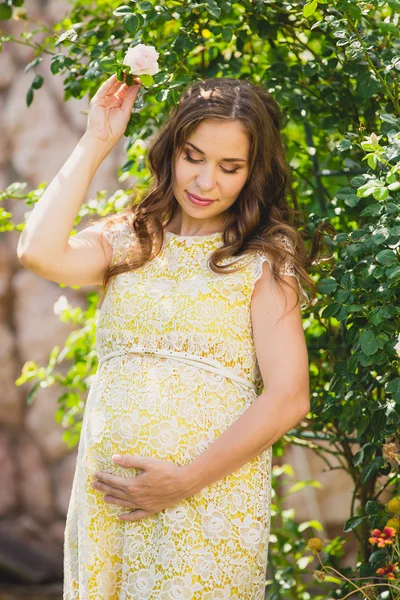 Donna incinta in giardino sta tenendo pancia — Foto Stock