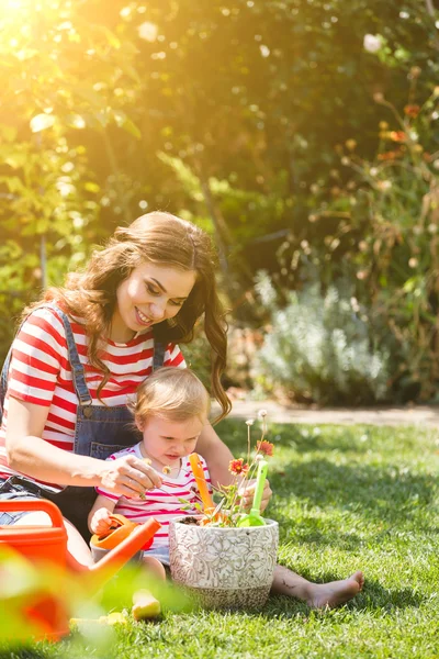 Mujer embarazada con hija pequeña en el jardín . —  Fotos de Stock