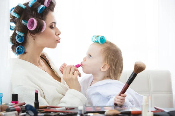 Mother and daughter are doing hair, manicures, makeup, having fun.