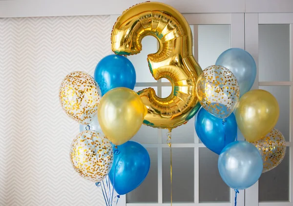 在婴儿三周岁生日的时候 用蓝色透明的气球装饰一个灯具室 上面装饰着金冠 气球束和带锯齿形壁纸背景上的3号气球 — 图库照片