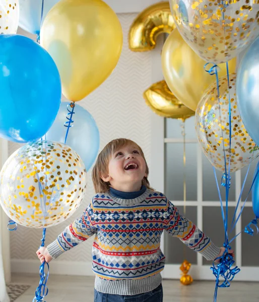 送给宝宝3岁生日的礼物 一个穿着漂亮毛衣 有花纹的小男孩拿着气球 带有斯堪的纳维亚风格的大窗户的明亮内部 — 图库照片