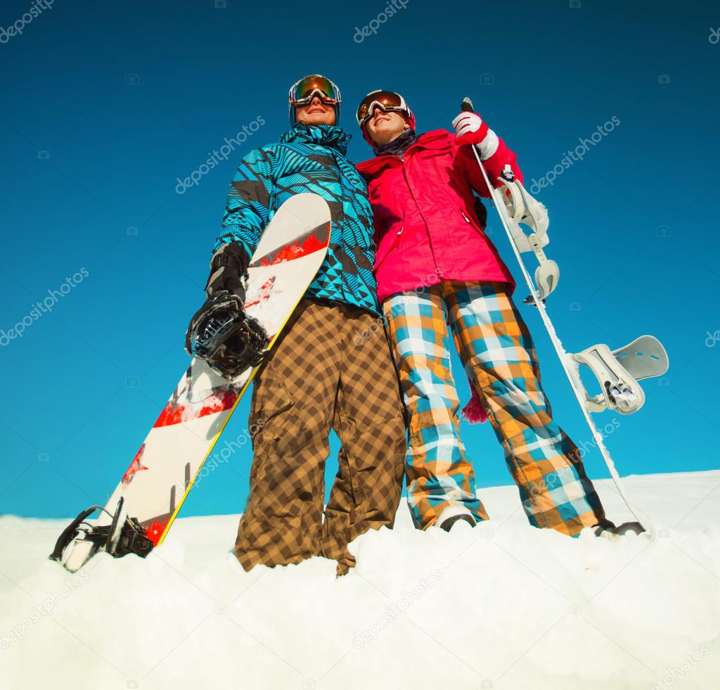 Girl and boy with snowboards on the snow