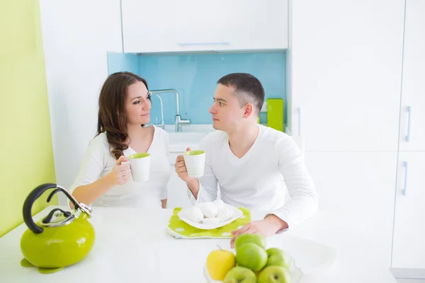 Молодая красивая пара ест на кухне — стоковое фото
