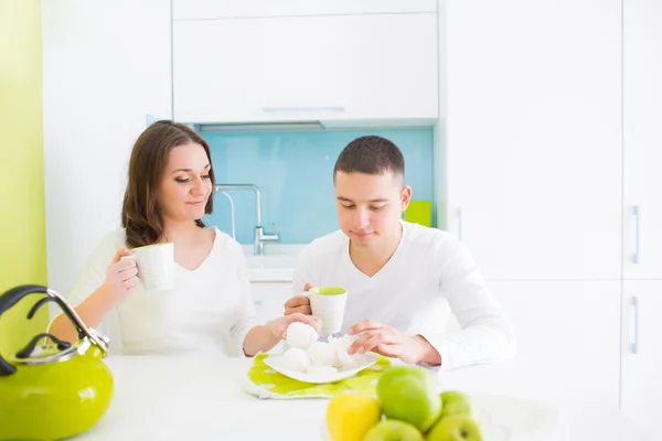 Young beautiful couple eating on kitchen — Stock Photo, Image