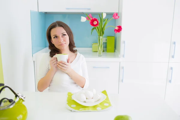 Jovem bela mulher comendo na cozinha — Fotografia de Stock