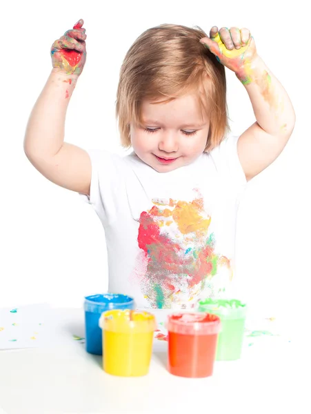 Маленькая девочка играет с красками для пальцев — стоковое фото