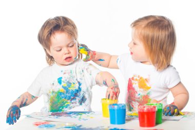 Küçük bir çocuk ve boyalar ile oynayan kız