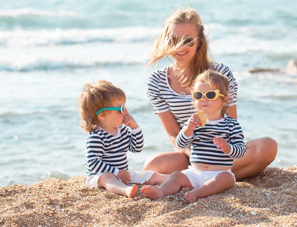 Moeder met kinderen op het strand — Stockfoto